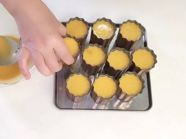 カヌレ生地を型の八分目まで注ぐ